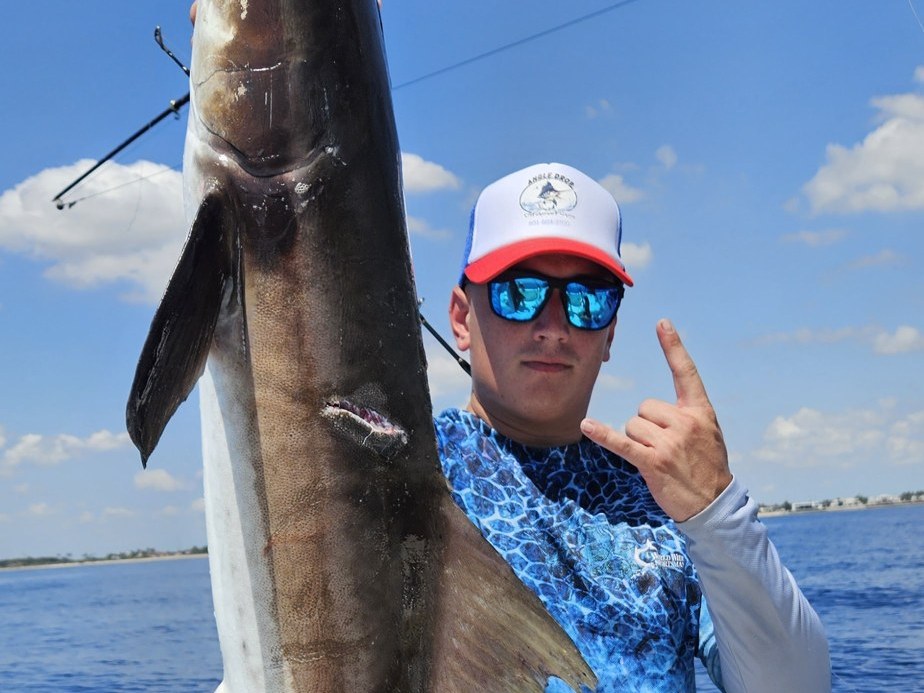 Angler holding a cobia caught offshore of Lake Worth, Florida