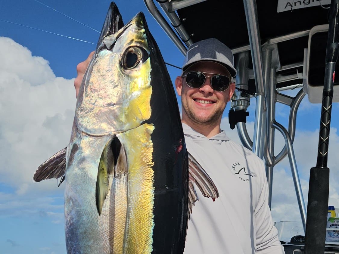 Angler holding a yellowfin tuna aboard the Angle Drop Charters center console off Palm Beach