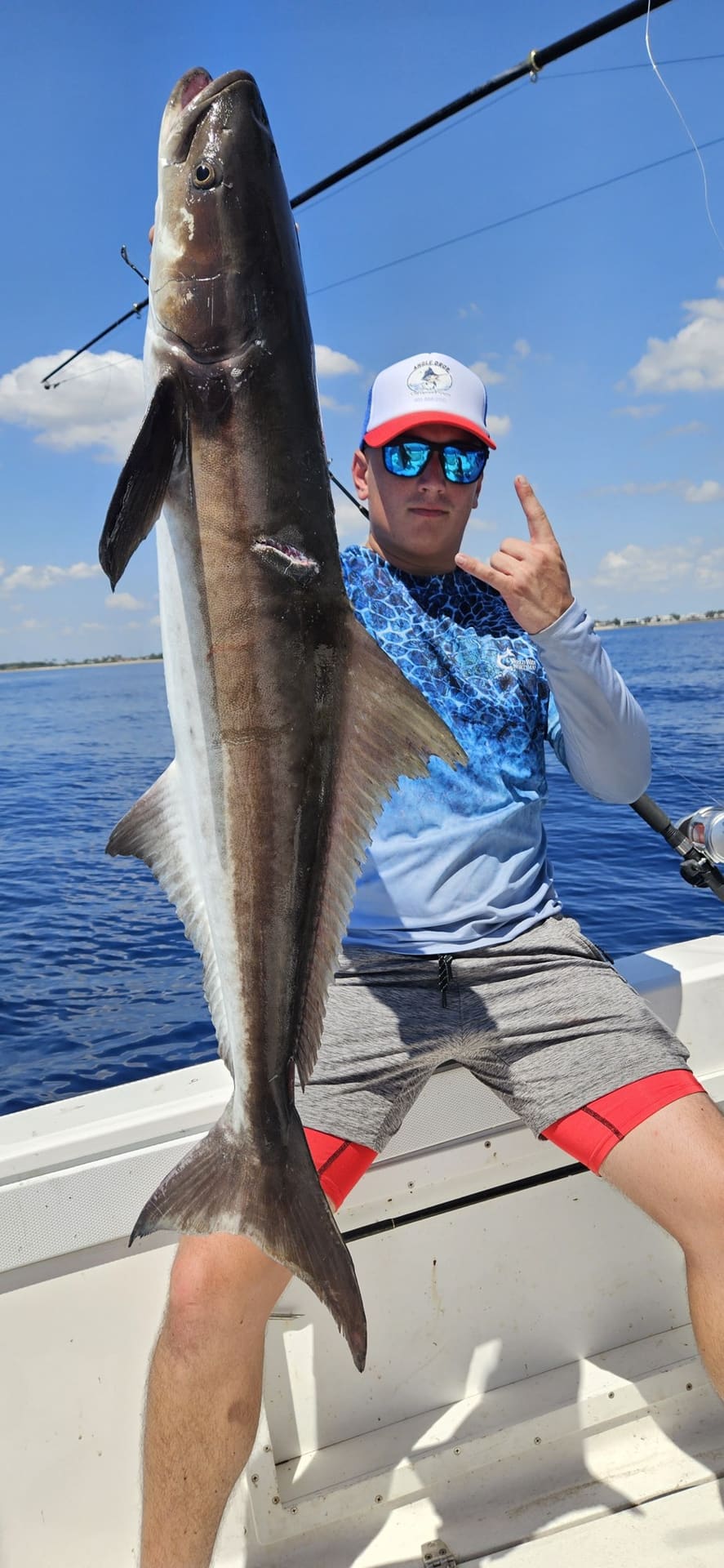 Angler holding a cobia caught offshore of Lake Worth, Florida