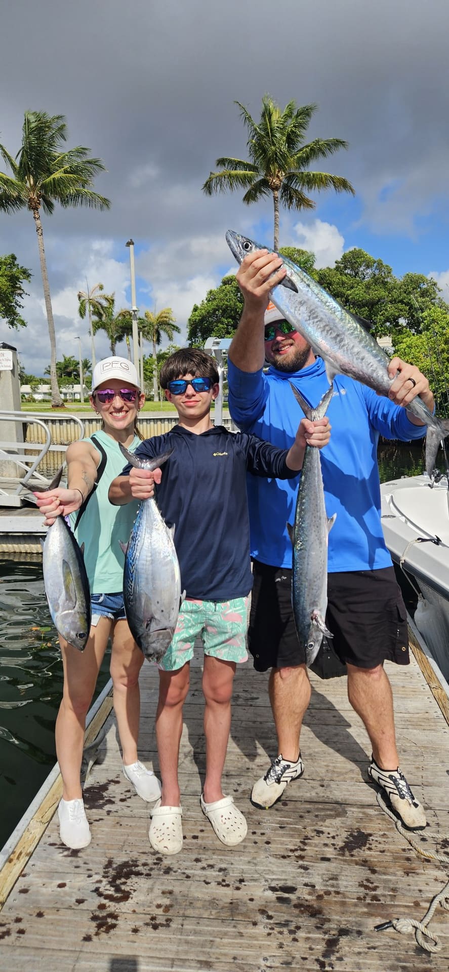 Three anglers on the dock showing off their catch after an Angle Drop Charters trip