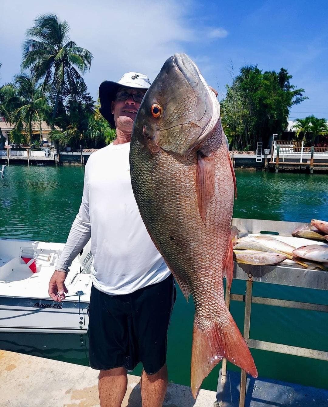 Angler holding a mutton snapper on the dock after a Boynton Beach reef fishing trip