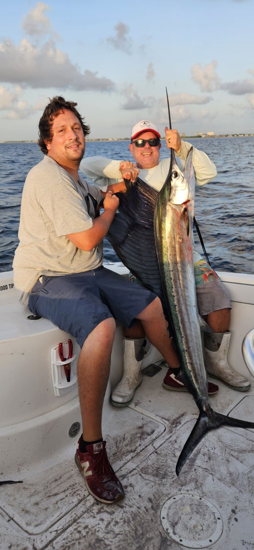 Two anglers with a sailfish landed on a Palm Beach sailfish charter