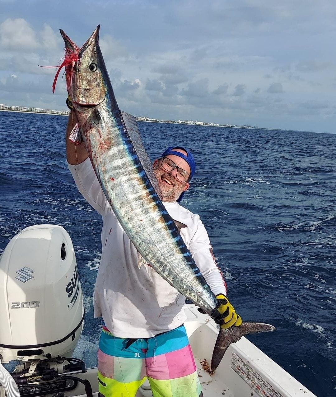 Angler lifting a wahoo caught in the Gulf Stream off Palm Beach County on a charter