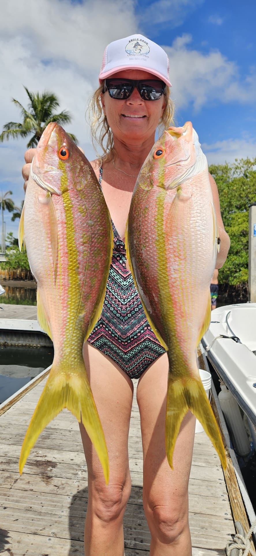 Angler holding two yellowtail snapper caught on the reef off Boynton Beach