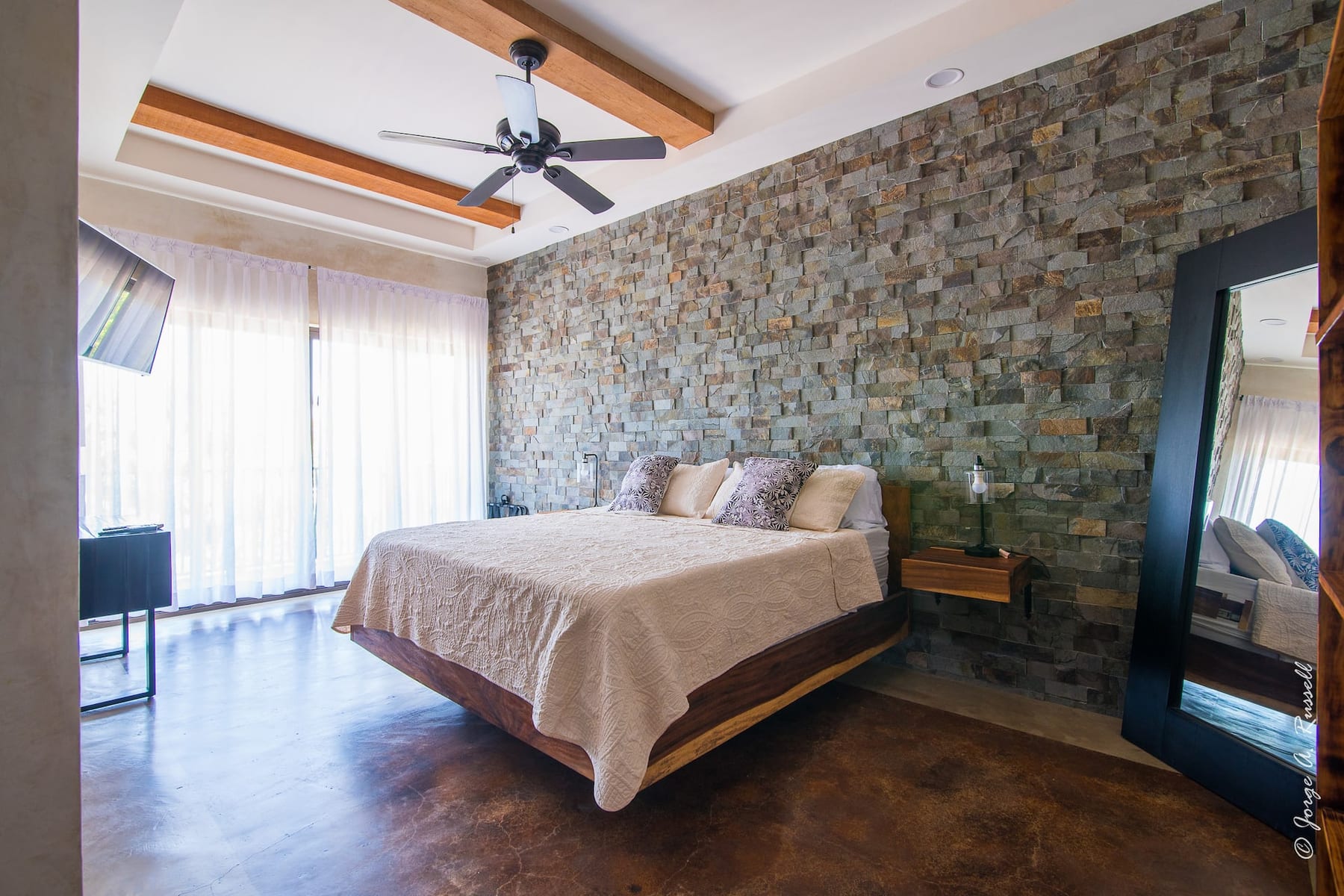 The villa's king room with a stone feature wall