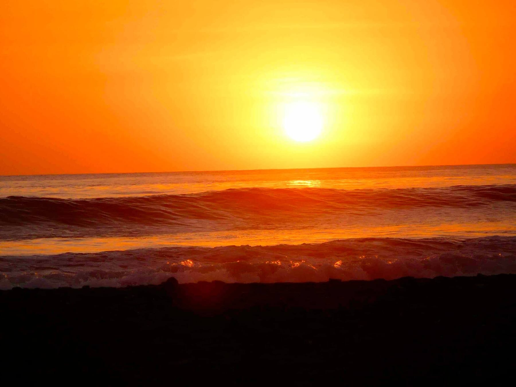 An orange sun setting into the Pacific