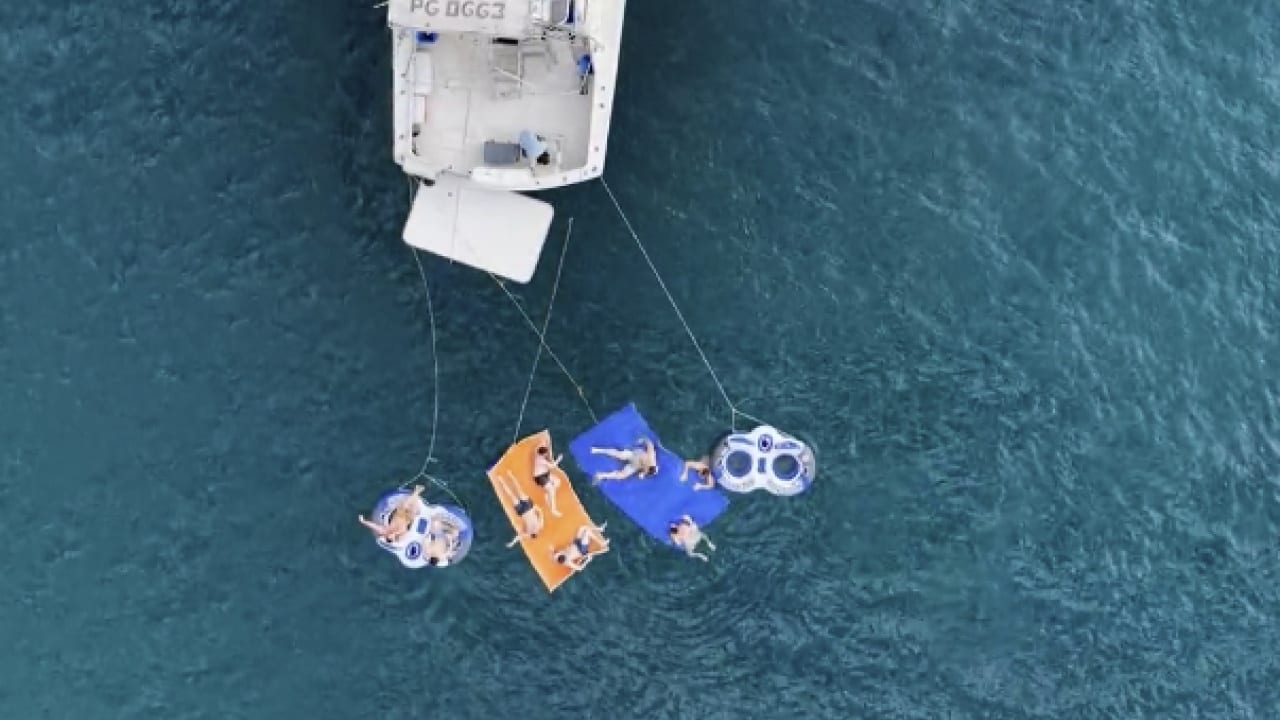 Guests on floats tied off the yacht's stern