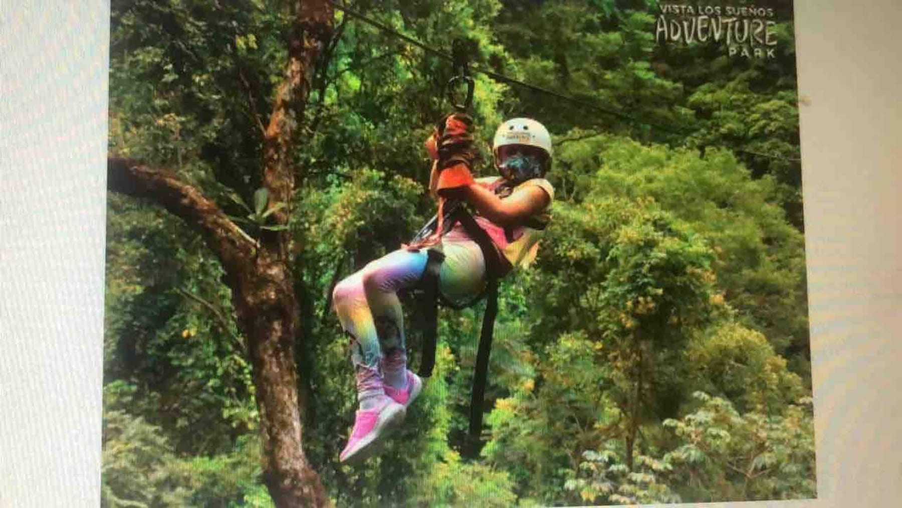 A rider on a zipline through the rainforest canopy