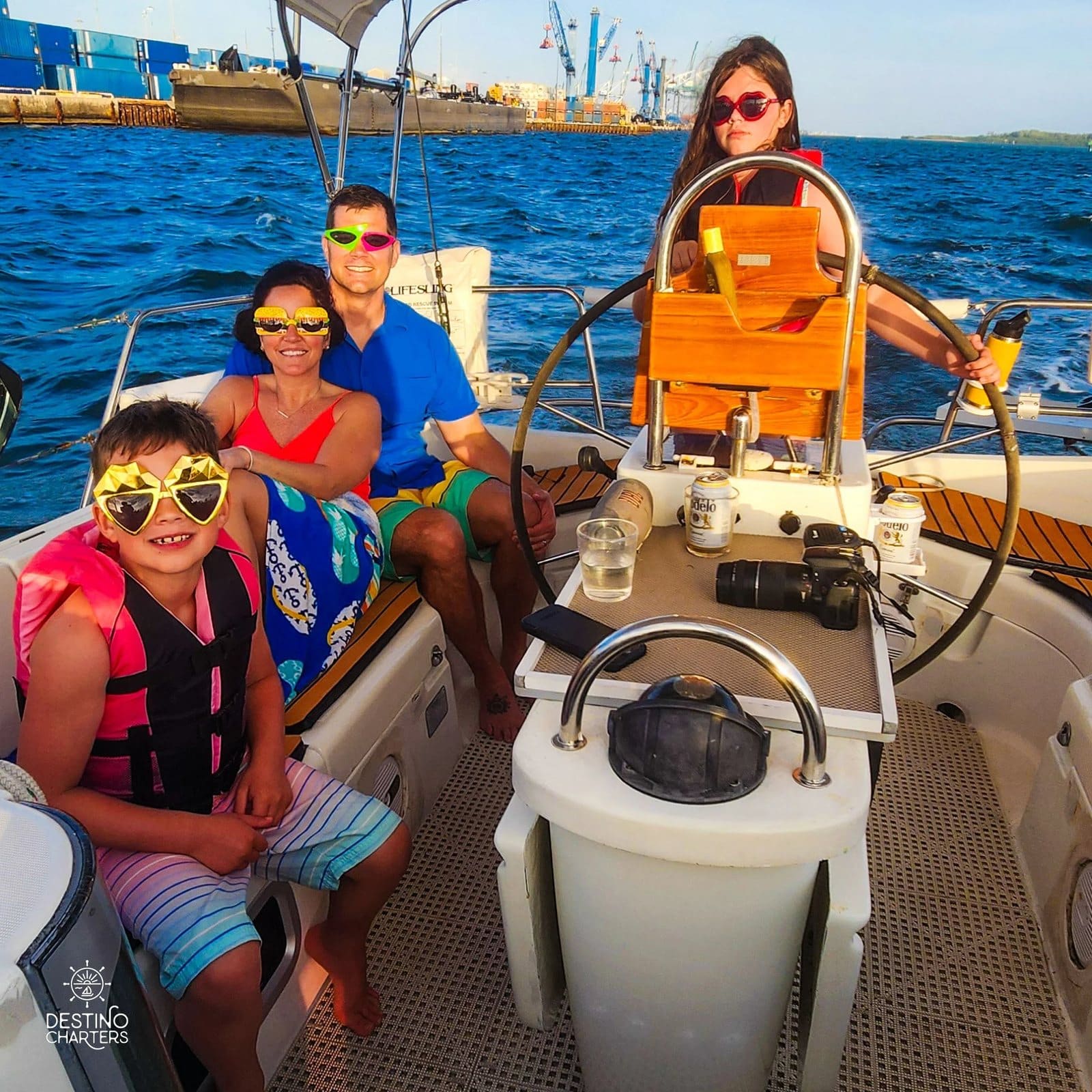 A family in party sunglasses aboard, a girl at the wheel