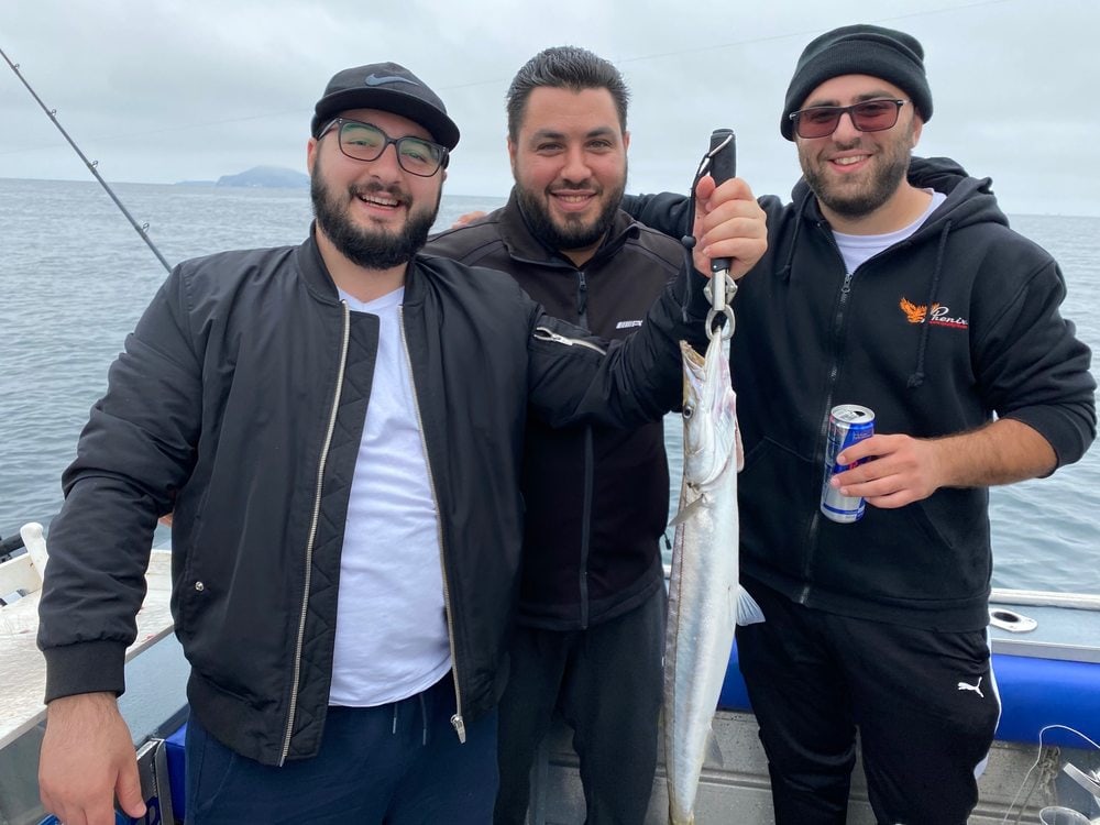 Three friends with a fish on the deck