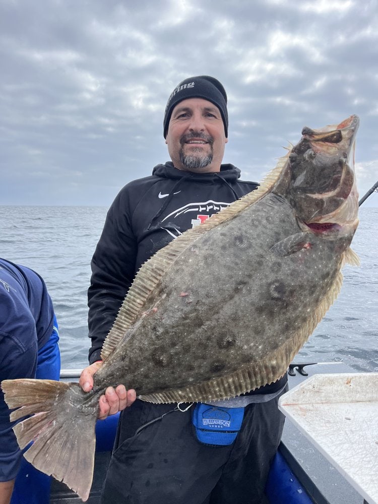 An angler holding a halibut