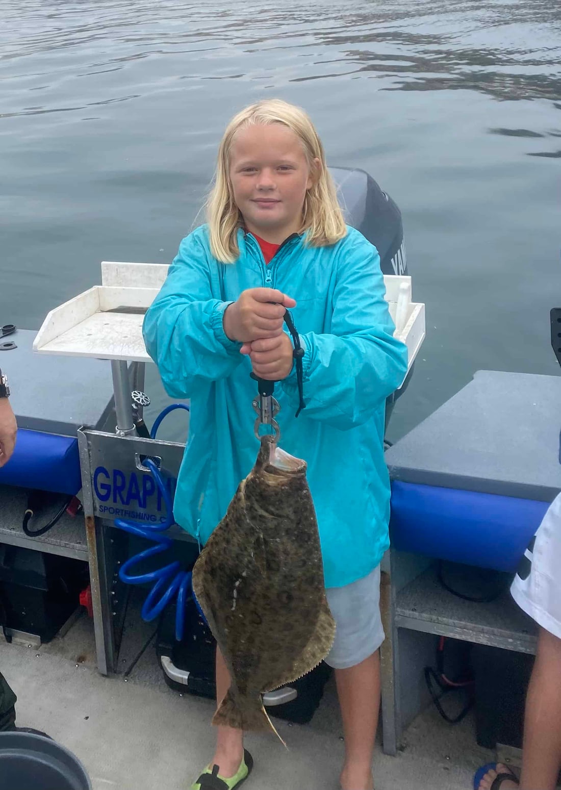 A young angler holding a halibut