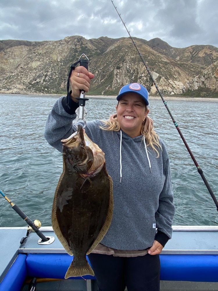 An angler holding a halibut on the deck