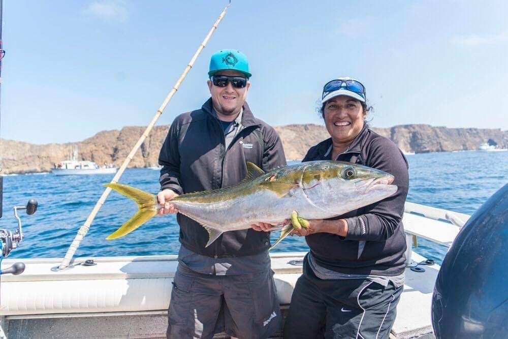 Two anglers holding a yellowtail