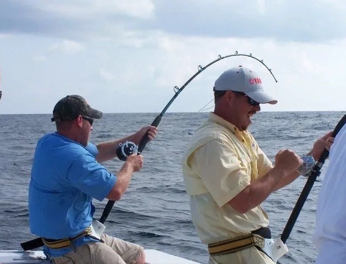 Two anglers bent into fish off the stern