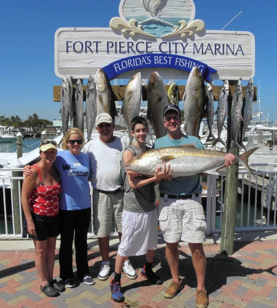 A family with the day's catch under the Fort Pierce City Marina sign