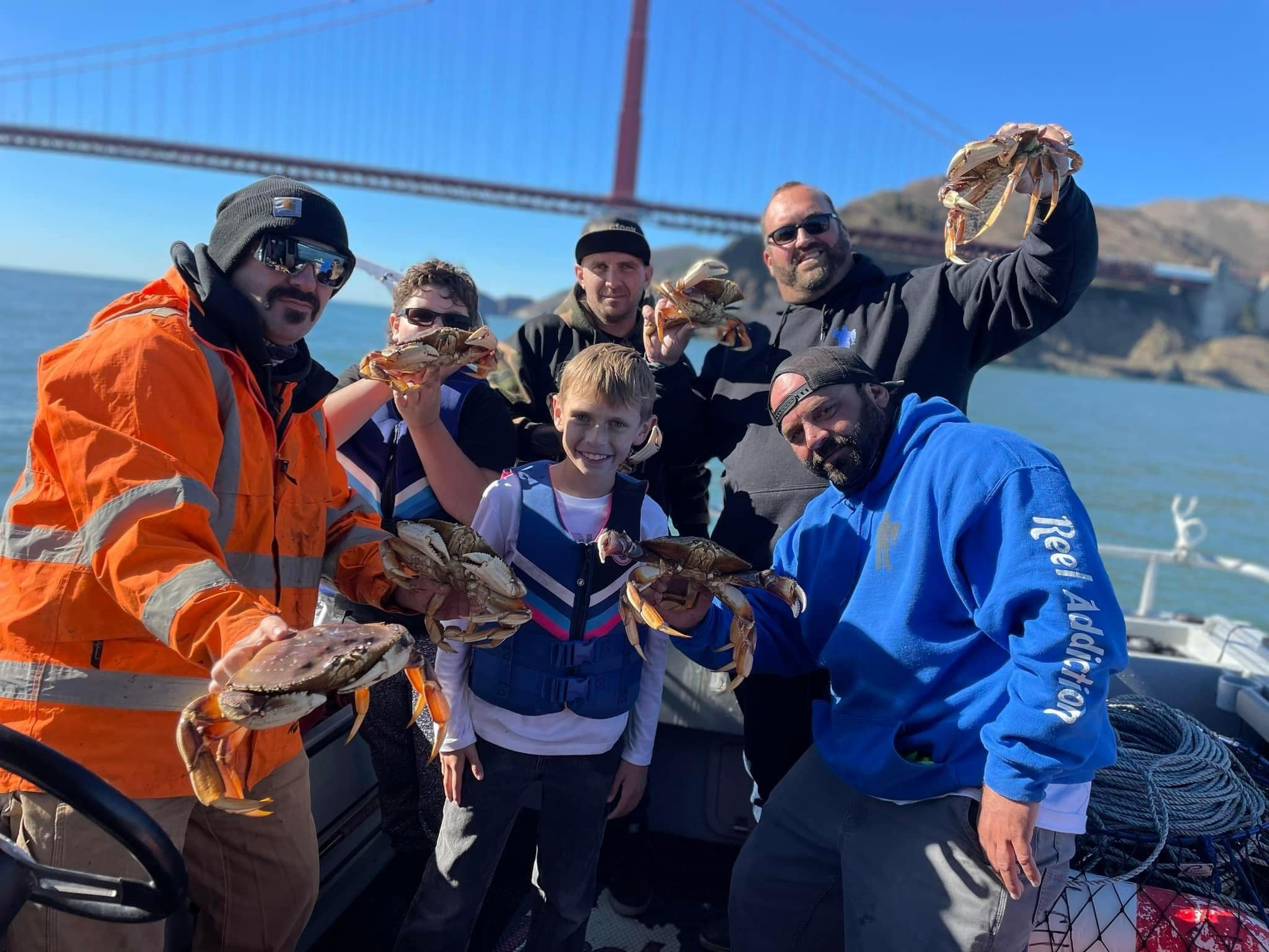 A family holding Dungeness crab with the Golden Gate Bridge behind
