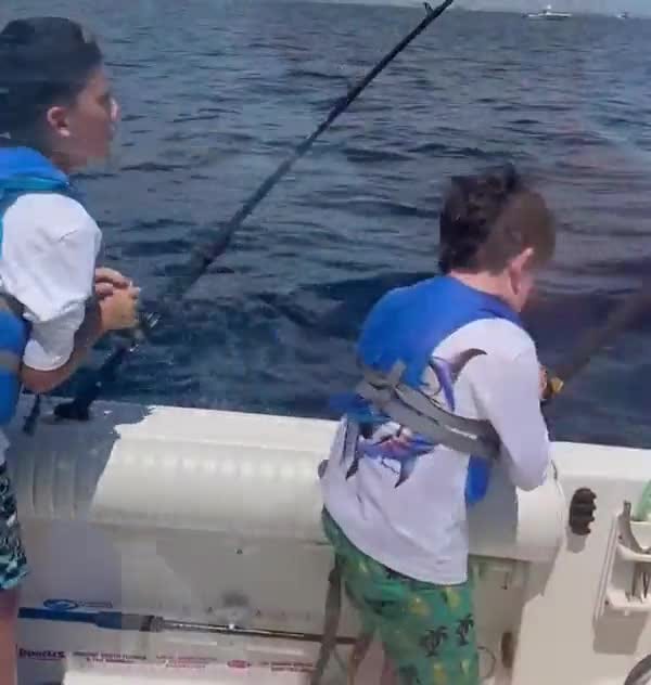 Two young anglers hooked up off the back of the boat