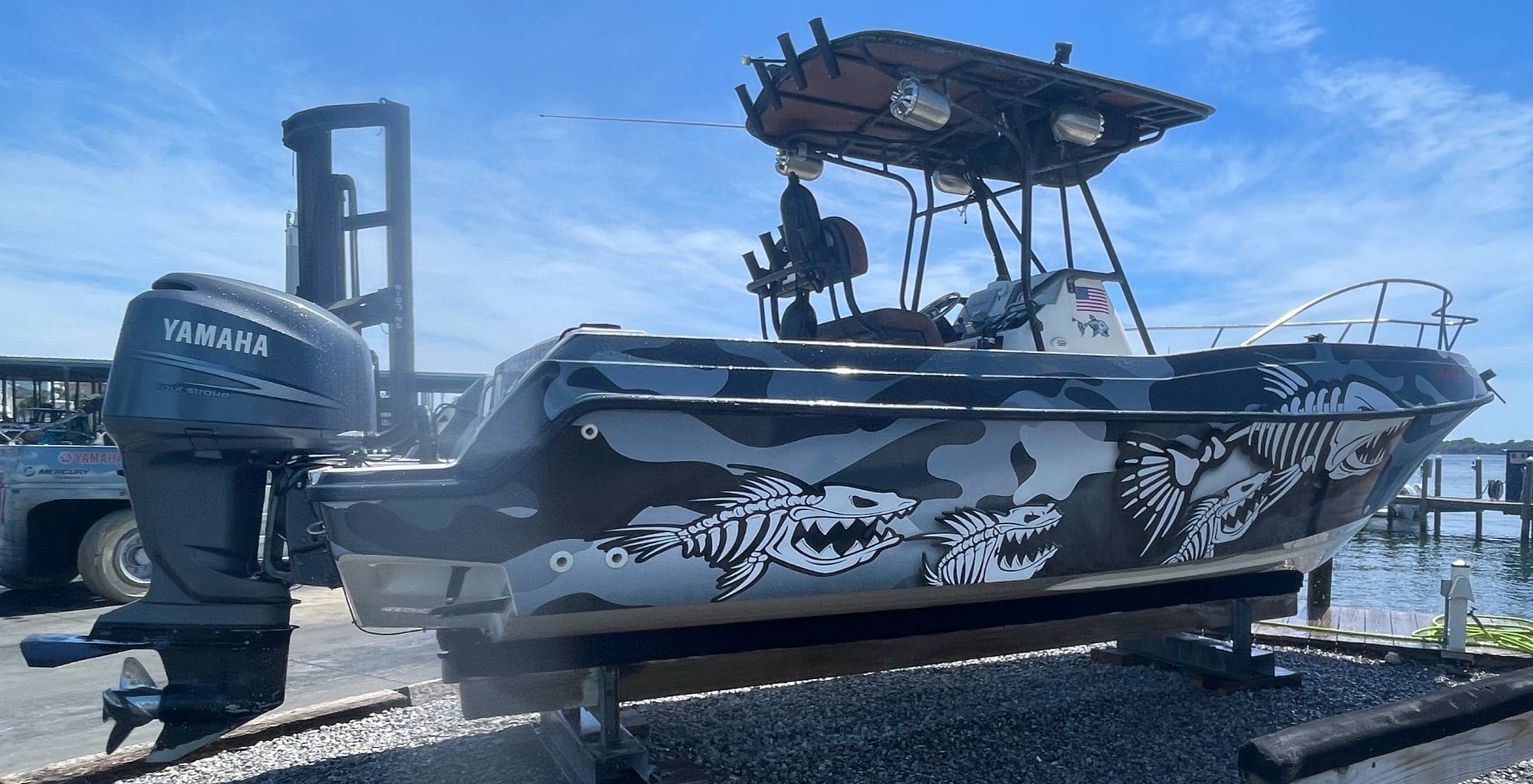 The Lady Mari, Salty Anchor Charters' boat, in a black and grey camo wrap on the lift at Shalimar Harbor Marina