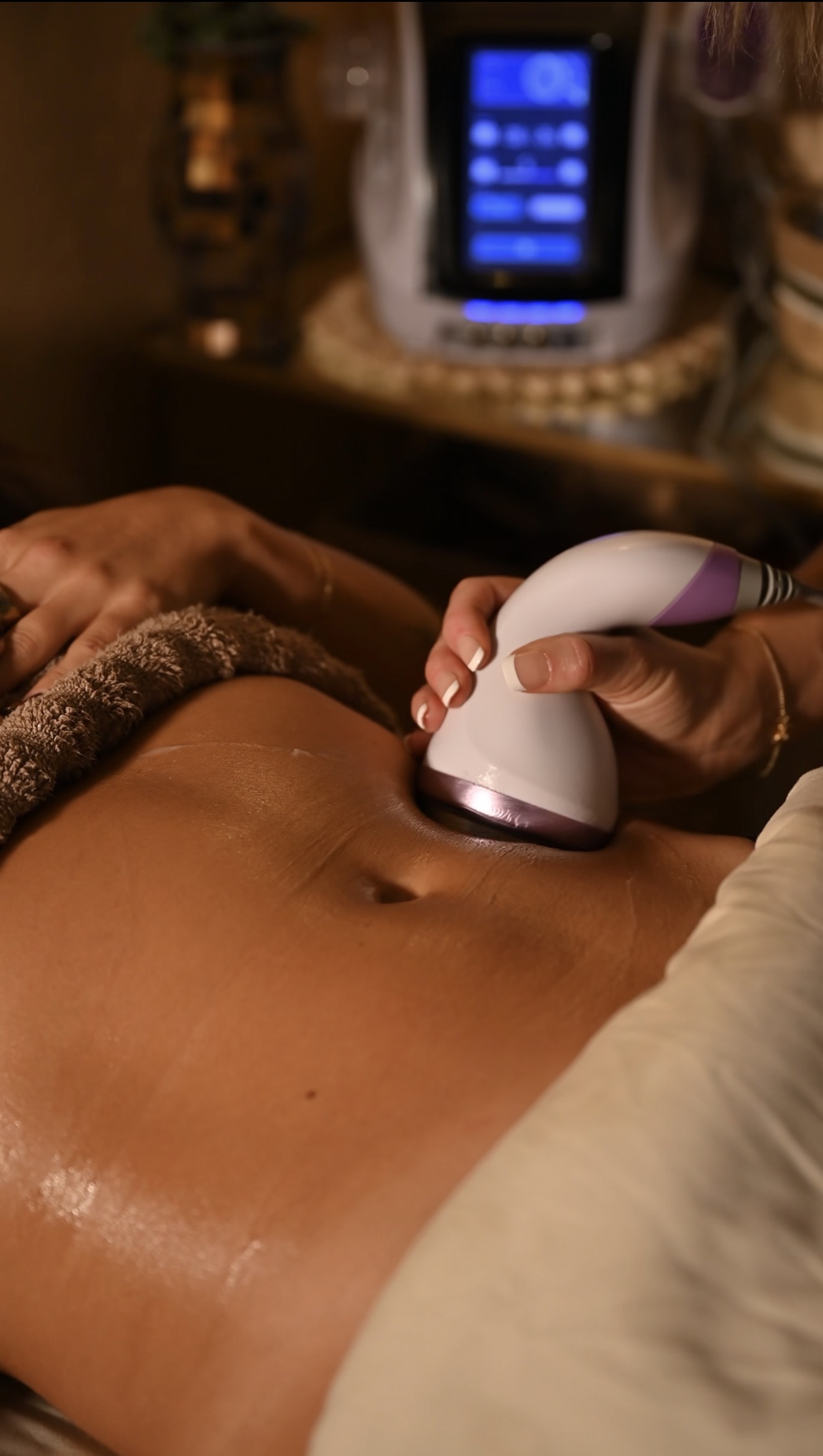 The sculpting handpiece in use on a client's stomach during a treatment